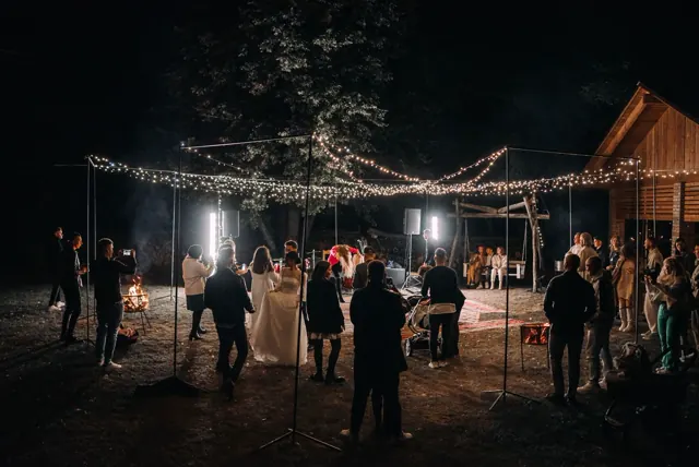 Wedding guests at night around a luminous white dance floor